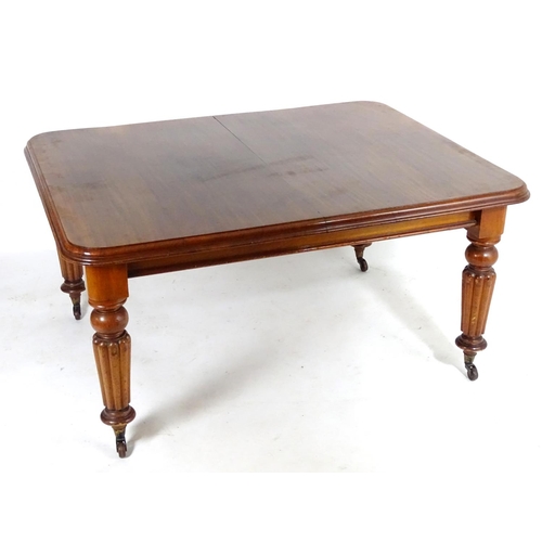 1368 - A late 19thC mahogany dining table, having a moulded edge above four turned tapering legs with reede... 