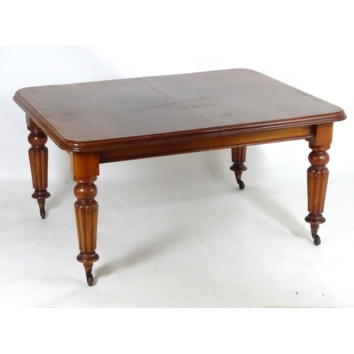 1368 - A late 19thC mahogany dining table, having a moulded edge above four turned tapering legs with reede... 