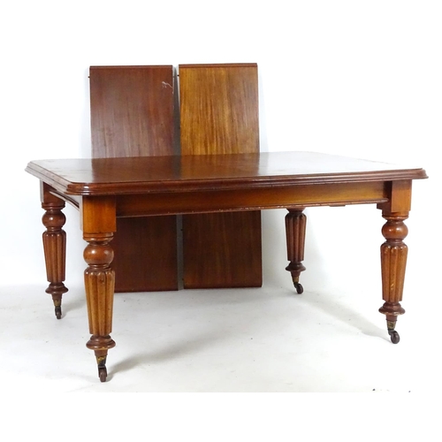 1368 - A late 19thC mahogany dining table, having a moulded edge above four turned tapering legs with reede... 