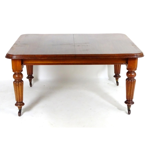 1368 - A late 19thC mahogany dining table, having a moulded edge above four turned tapering legs with reede... 