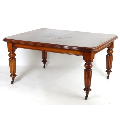 1368 - A late 19thC mahogany dining table, having a moulded edge above four turned tapering legs with reede... 