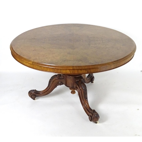 1552 - A mid 19thC walnut breakfast / dining table with a large moulded top above a carved base and three c... 