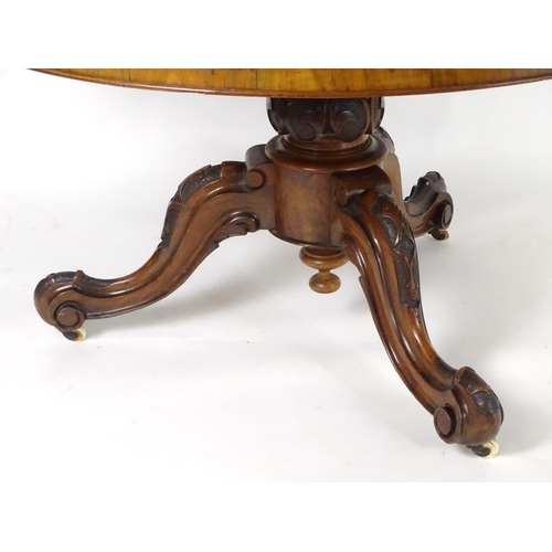 1552 - A mid 19thC walnut breakfast / dining table with a large moulded top above a carved base and three c... 