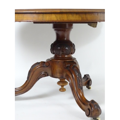 1552 - A mid 19thC walnut breakfast / dining table with a large moulded top above a carved base and three c... 