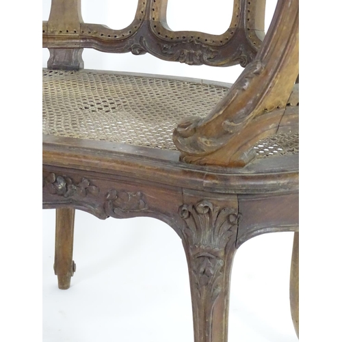 1559 - An early 20thC French Louis VI style chair with a carved and moulded frame above a caned seat, stand... 