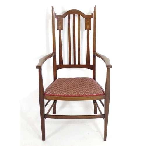 1560 - An early 20thC mahogany Arts & Crafts chair with a shaped, slatted backrest and marquetry inlay. 21