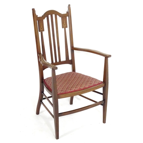 1560 - An early 20thC mahogany Arts & Crafts chair with a shaped, slatted backrest and marquetry inlay. 21