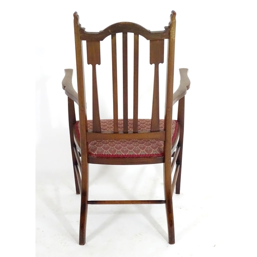 1560 - An early 20thC mahogany Arts & Crafts chair with a shaped, slatted backrest and marquetry inlay. 21