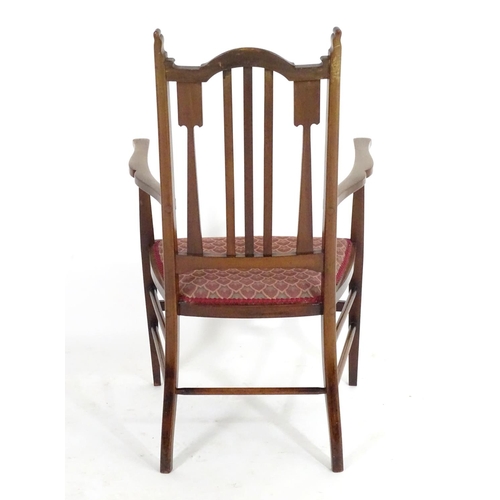 1560 - An early 20thC mahogany Arts & Crafts chair with a shaped, slatted backrest and marquetry inlay. 21