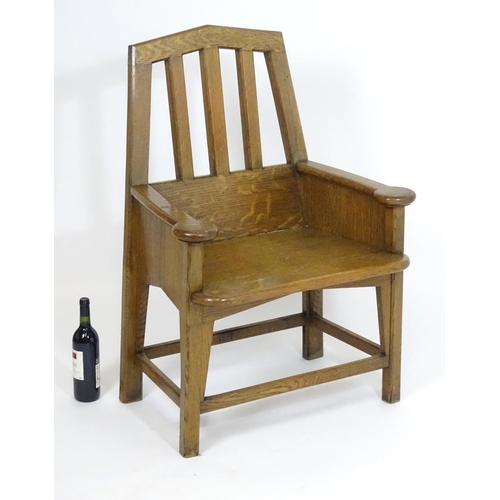 1396 - An Arts and Crafts oak throne chair with a pointed, slatted backrest and a chamfered frame and curve... 