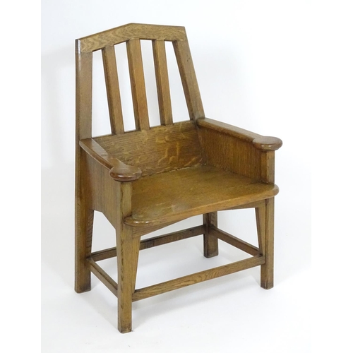 1396 - An Arts and Crafts oak throne chair with a pointed, slatted backrest and a chamfered frame and curve... 