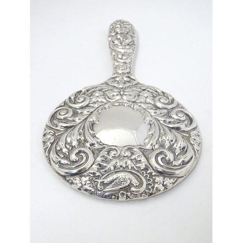 415 - A silver handled mirror with embossed decoration, hallmarked Birmingham 1977, maker W. I. Broadway &... 