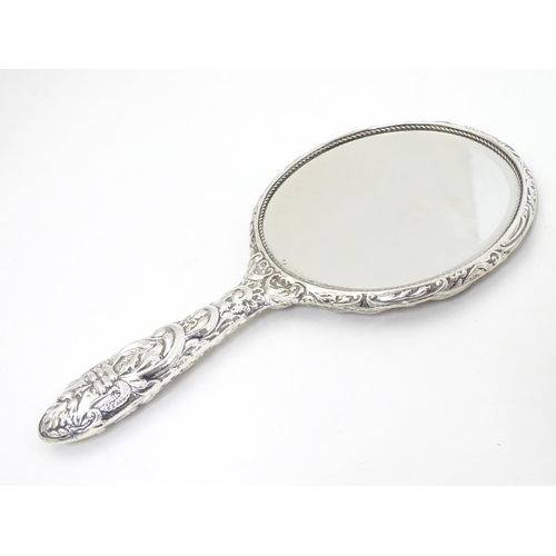 415 - A silver handled mirror with embossed decoration, hallmarked Birmingham 1977, maker W. I. Broadway &... 