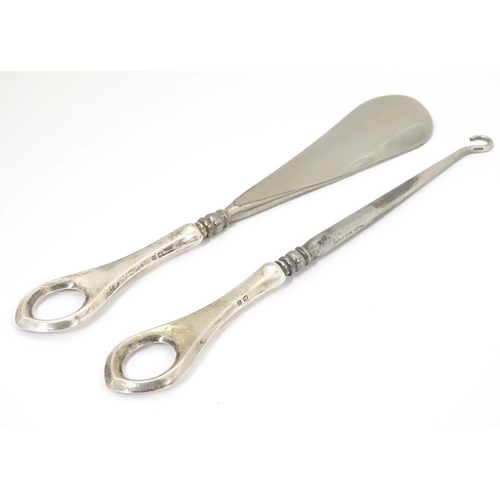 439 - A silver handled shoe horn and a silver handled lace / button hook. Both hallmarked Birmingham 1913 ... 