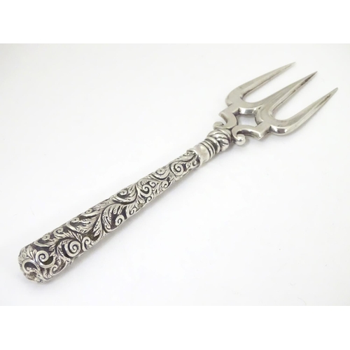 440 - A Victorian silver bread fork with an embossed handle, the central tine hallmarked Birmingham 1898, ... 