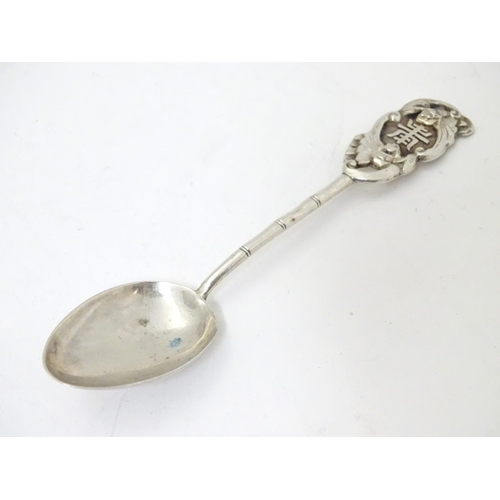 459 - An Oriental white metal teaspoon with stylised bamboo handle surmounted by bat decoration. Marked wi... 