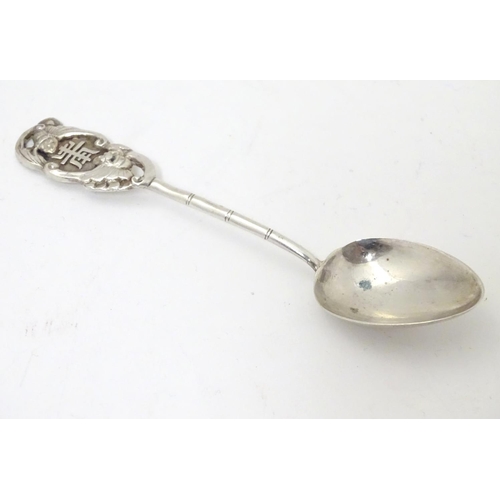 459 - An Oriental white metal teaspoon with stylised bamboo handle surmounted by bat decoration. Marked wi... 