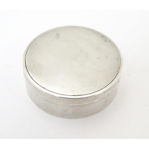 465 - A Continental .935 sterling silver pill box of circular form with engine turned decoration and gilde... 