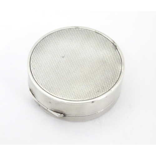 465 - A Continental .935 sterling silver pill box of circular form with engine turned decoration and gilde... 