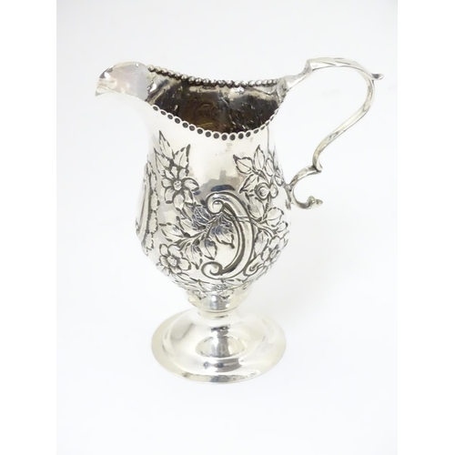 466 - A Victorian silver cream jug with embossed floral and C scroll decoration hallmarked London 1898, ma... 