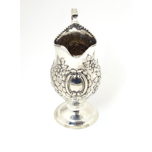 466 - A Victorian silver cream jug with embossed floral and C scroll decoration hallmarked London 1898, ma... 