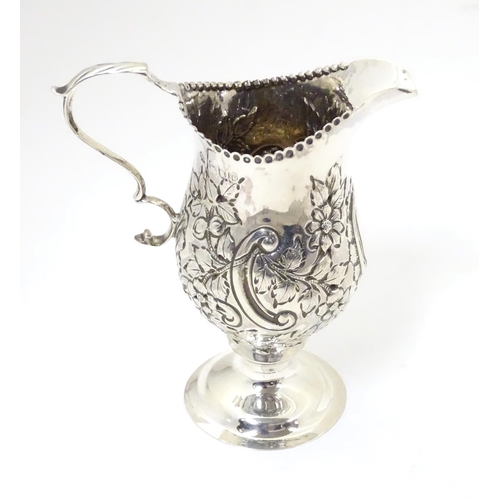 466 - A Victorian silver cream jug with embossed floral and C scroll decoration hallmarked London 1898, ma... 