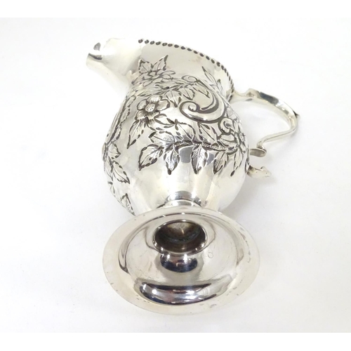 466 - A Victorian silver cream jug with embossed floral and C scroll decoration hallmarked London 1898, ma... 