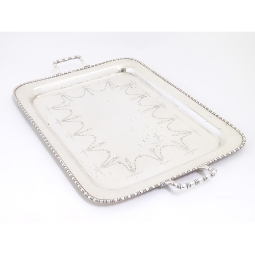 498 - A large silver plate two handled tray with engraved decoration 26