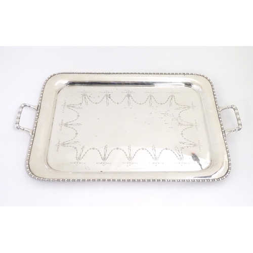 498 - A large silver plate two handled tray with engraved decoration 26