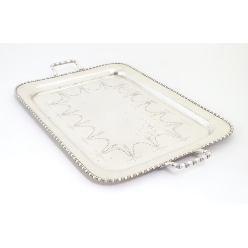 498 - A large silver plate two handled tray with engraved decoration 26