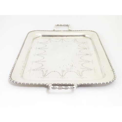 498 - A large silver plate two handled tray with engraved decoration 26