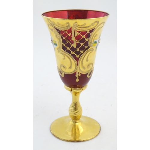 220 - A ruby glass goblet with gilt and enamel overlay. Approx. 7