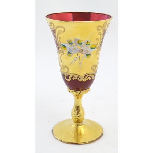 220 - A ruby glass goblet with gilt and enamel overlay. Approx. 7