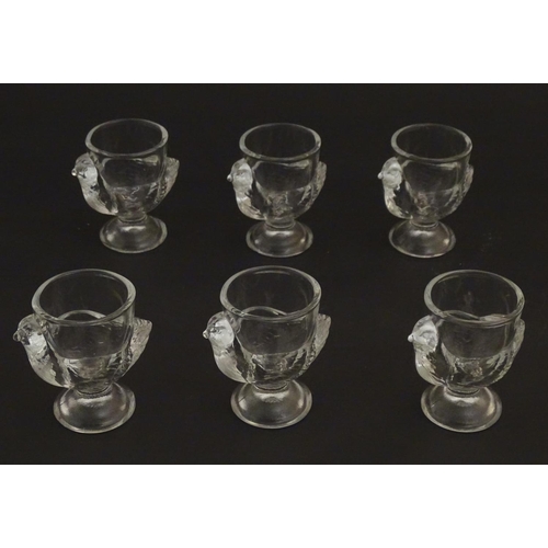 222 - A set of 6 moulded glass egg cups of pedestal form with chicken decoration. 2 3/4