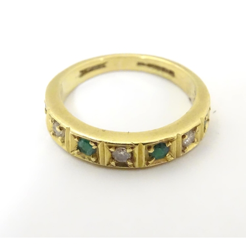 503 - An 18ct gold ring set with 4 emeralds and 3 diamonds. Ring size approx K