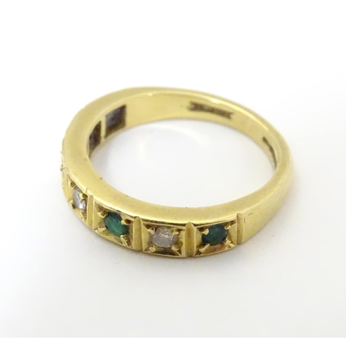 503 - An 18ct gold ring set with 4 emeralds and 3 diamonds. Ring size approx K