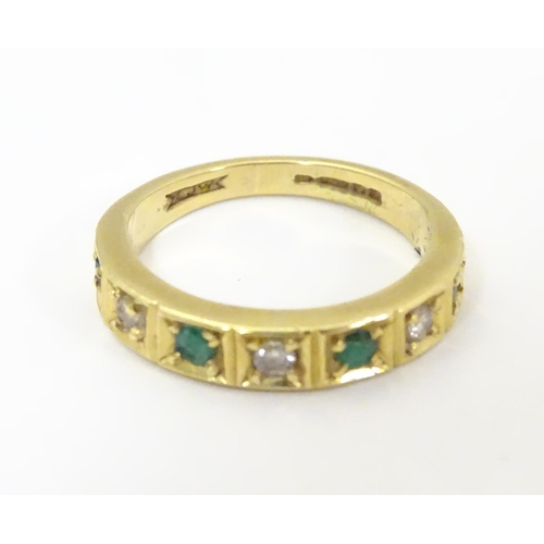 503 - An 18ct gold ring set with 4 emeralds and 3 diamonds. Ring size approx K