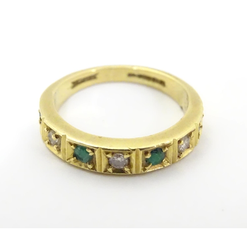 503 - An 18ct gold ring set with 4 emeralds and 3 diamonds. Ring size approx K