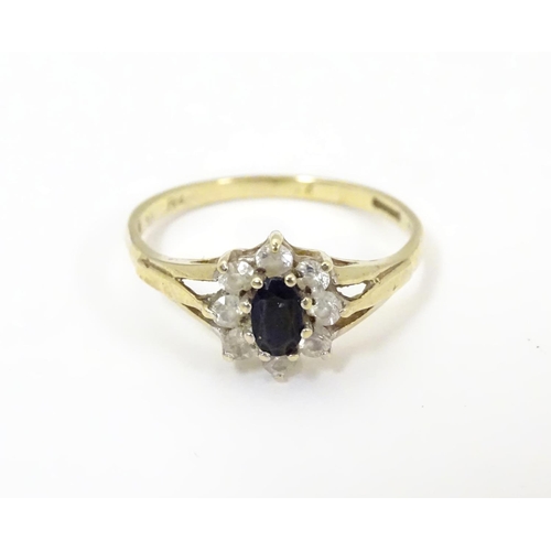 506 - A 9ct gold sapphire floral cluster ring bordered by white stones. Ring size approx N 1/2