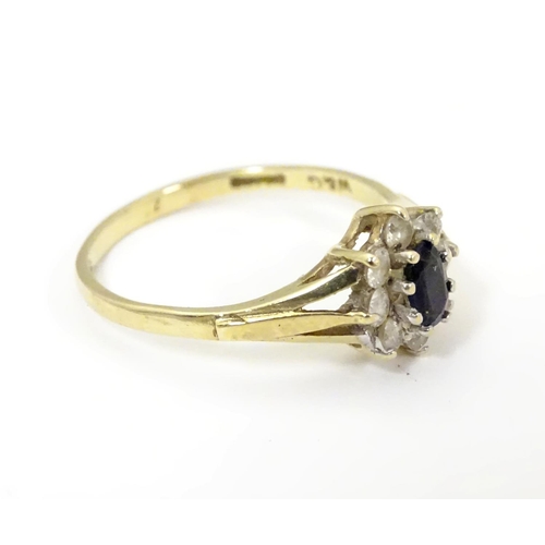 506 - A 9ct gold sapphire floral cluster ring bordered by white stones. Ring size approx N 1/2