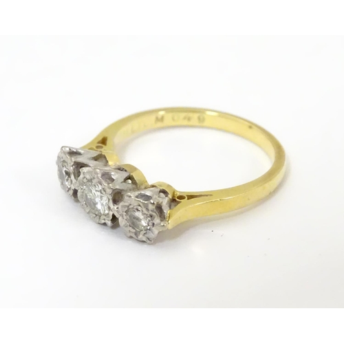 509 - An 18ct gold ring set with trio of diamonds. ring size approx K.