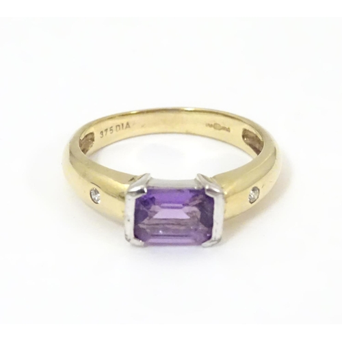 511 - A 9ct gold amethyst and diamond ring, the central amethyst flanked by two diamonds  . Ring size appr... 