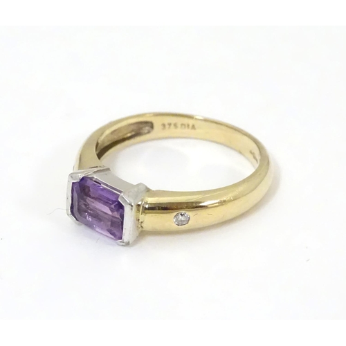 511 - A 9ct gold amethyst and diamond ring, the central amethyst flanked by two diamonds  . Ring size appr... 