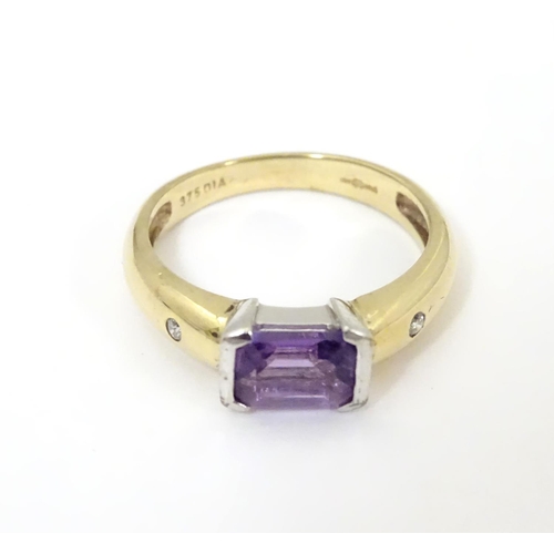 511 - A 9ct gold amethyst and diamond ring, the central amethyst flanked by two diamonds  . Ring size appr... 