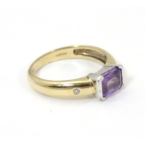 511 - A 9ct gold amethyst and diamond ring, the central amethyst flanked by two diamonds  . Ring size appr... 