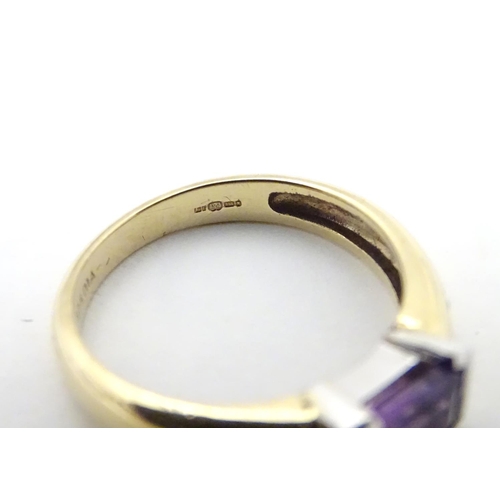 511 - A 9ct gold amethyst and diamond ring, the central amethyst flanked by two diamonds  . Ring size appr... 