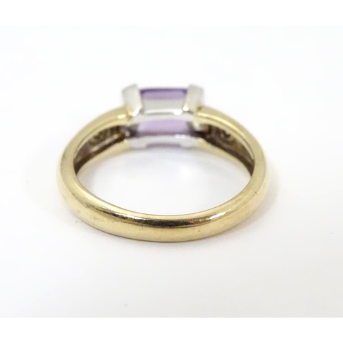 511 - A 9ct gold amethyst and diamond ring, the central amethyst flanked by two diamonds  . Ring size appr... 