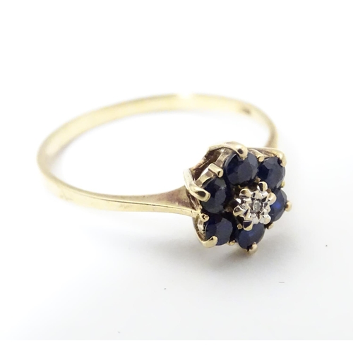 515 - A 9ct gold ring set with central diamond bordered by 6 sapphires in a cluster setting. Ring size app... 