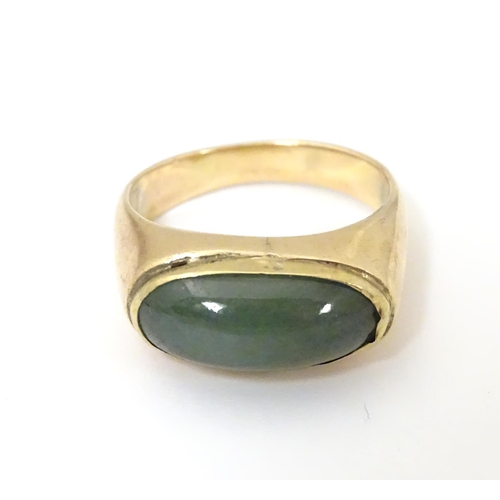 530 - A 14ct gold ring set with jade cabochon. Ring size approx. P 1/2