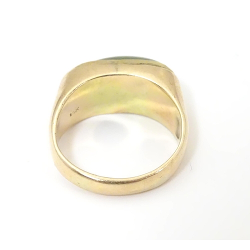 530 - A 14ct gold ring set with jade cabochon. Ring size approx. P 1/2